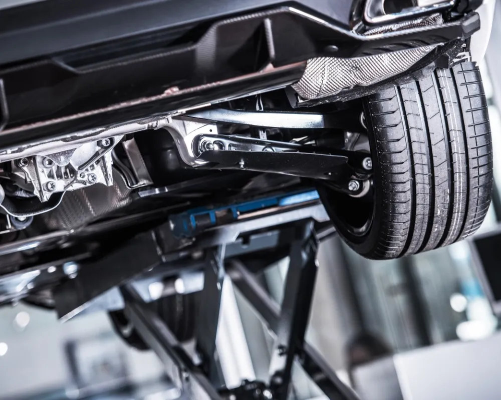 Close-up view of a vehicle’s underside, showing suspension parts such as springs, control arms, and shock absorbers.