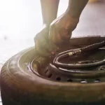 Juego de neumáticos listos para montaje con herramientas neumáticas en centro especializado de reparación de automóviles en Georgetown