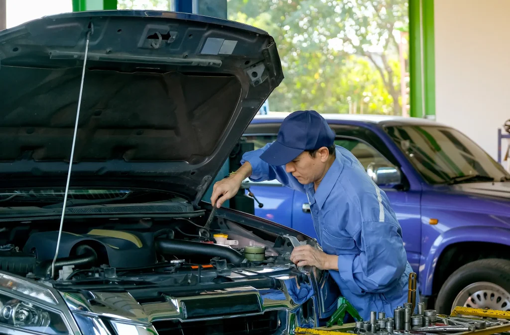 Professional technician checking a pickup engine to provide reliable fleet maintenance services for business vehicles.