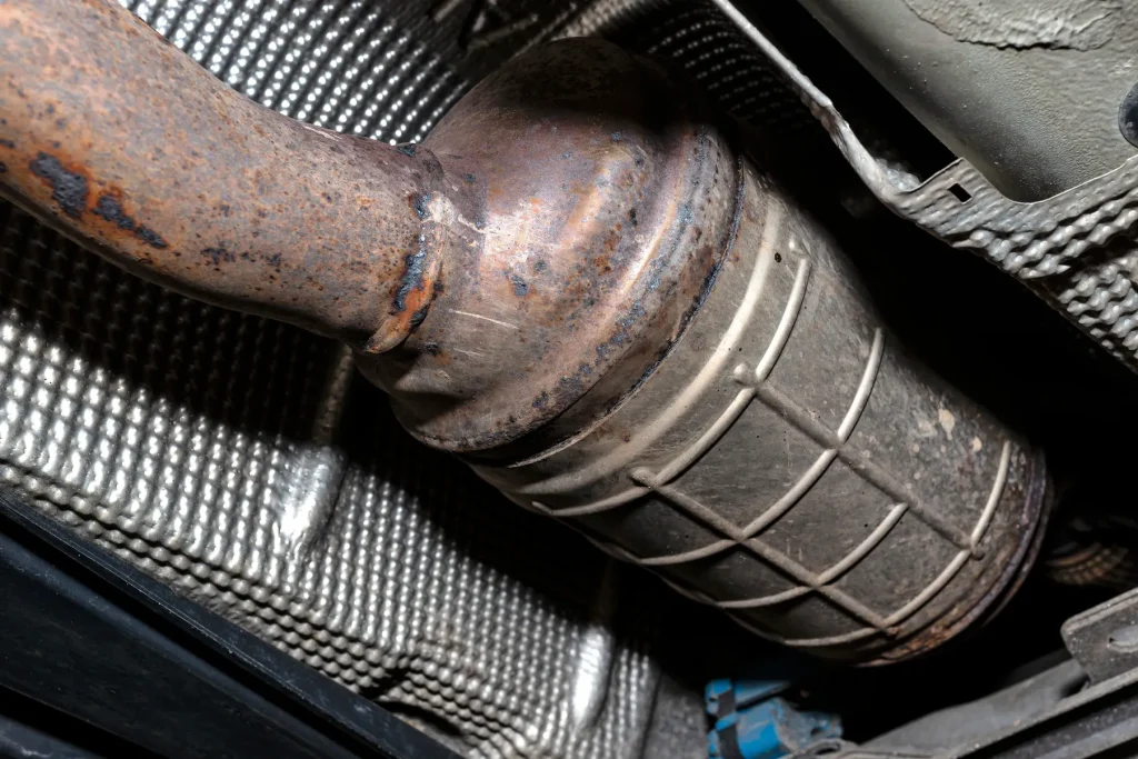 Close-up view of a catalytic converter with oxidation that requires muffler repair.