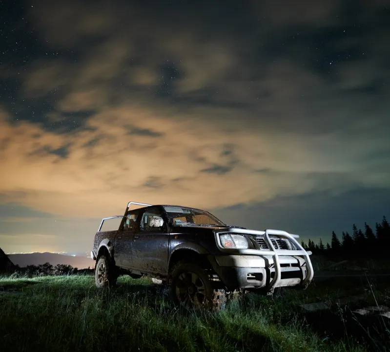 Muddy truck at night in grass. Getting stuck in the mud is tough, having diesel engine problems is tougher.