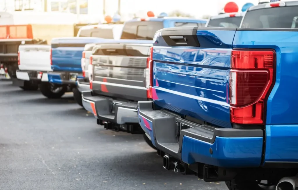 Blue and grey trucks parked. Checking used trucks for previous diesel engine problems is important.
